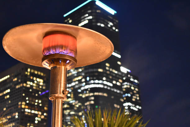 Patio Heater with skyscraper Glowing heat lamp on nighttime rooftop steven harrie stock pictures, royalty-free photos & images