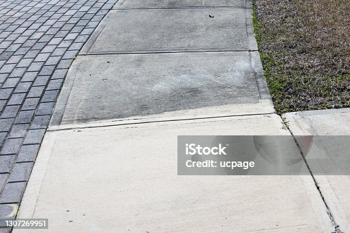 istock Patrially cleaned and partial irty cement sidewalk in front of a homeafter some of it has been pressure washed. 1307269951