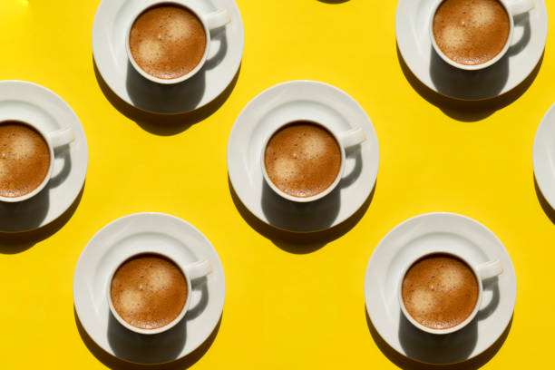 Pattern made of cup of cappuccino on yellow background stock photo