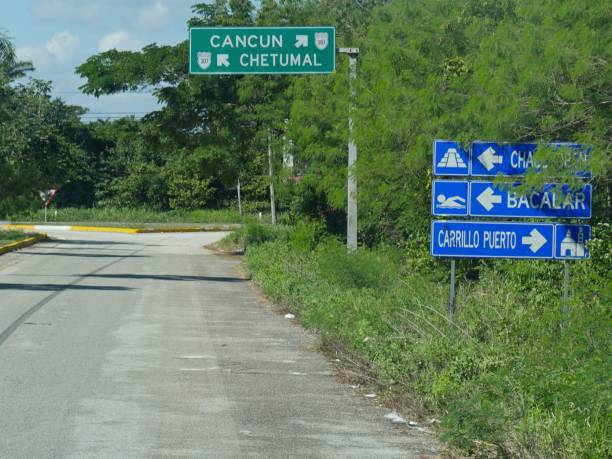 Paved road and intersection with directional signs to Cancun and Chetumal, Mexico, and other destinations. stock photo