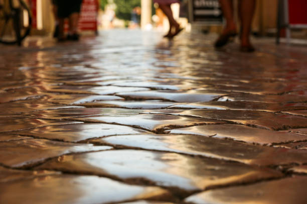 Paving stones from Roman times that have been polished smooth over centuries (focus detail) as a road surface stock photo