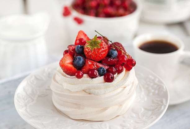 Pavlova meringue cake with fresh berries Pavlova meringue cake with fresh berries on white background pavlova dessert photos stock pictures, royalty-free photos & images