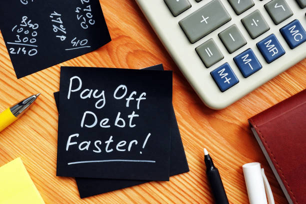 Pay off debt faster handwritten memo and calculator. stock photo