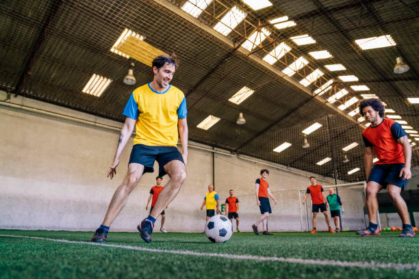 Payers in action during soccer match in indoor field stock photo