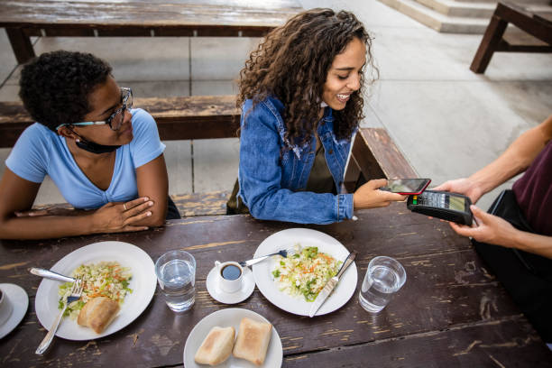 Paying By Phone Eating out during the Covid-19 pandemic. outdoor dining technology stock pictures, royalty-free photos & images