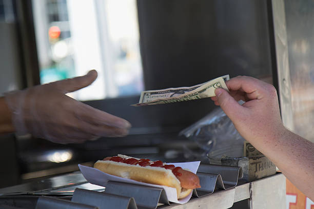 Paying for purchased hot dog stock photo