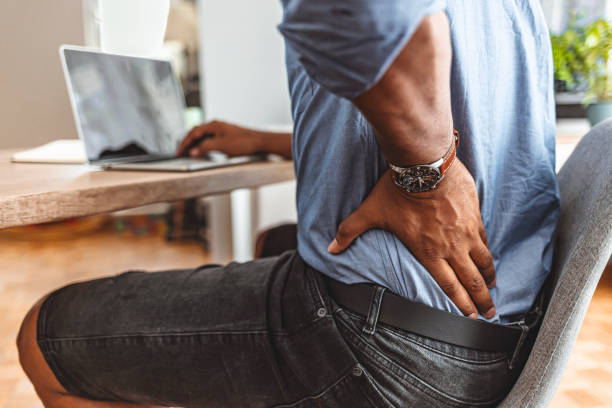 Paying the highest price for success Businessman working sitting at desk feels unhealthy suffers from lower back pain. Damage of intervertebral discs, spinal joints, compression of nerve roots caused by wrong posture and sedentary work. chronic illness stock pictures, royalty-free photos & images