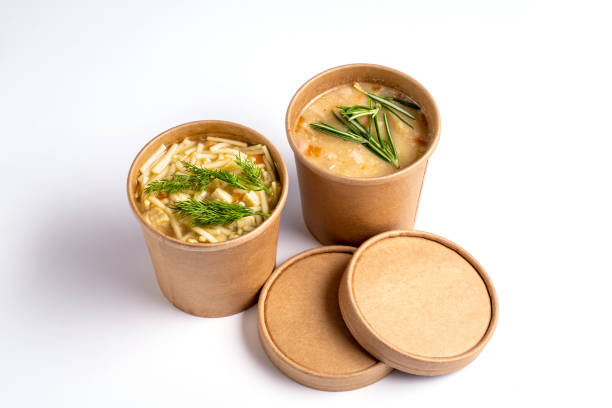 Pea and chicken soup in paper disposable cups for take-out or delivery of food on white background. stock photo