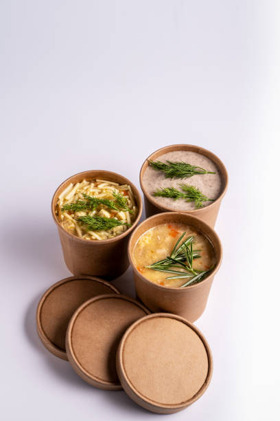 Pea, Mushroom and chicken soup in paper disposable cups for take-out or delivery of food on white background. stock photo
