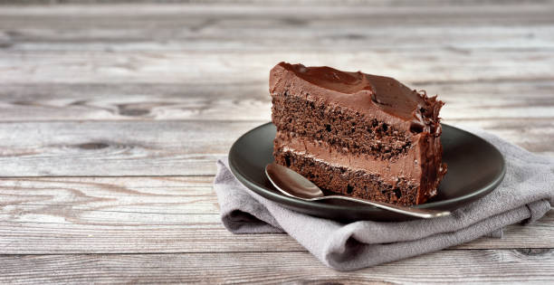 a peace of vegan chocolate davil cake on grey wooden background - bolos de chocolate imagens e fotografias de stock