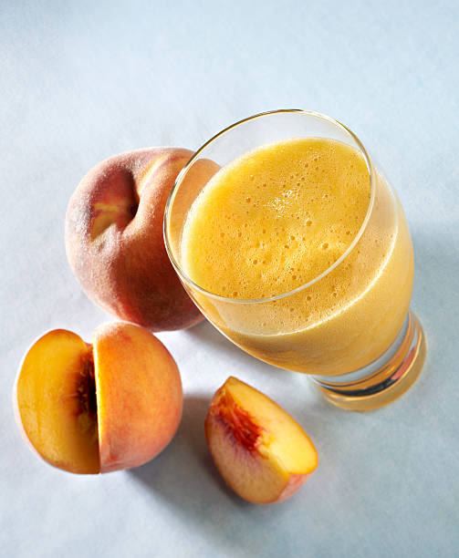 Peach Fruit Smoothie "Fruit Smoothie made with peaches, bananas and oranges. See other smoothies in my DRINKS or SWEETS lightboxes." peach smoothie stock pictures, royalty-free photos & images