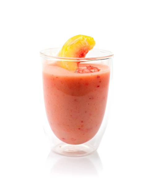 Peach Smoothie Glass of peach flavored smoothie with peach slice isolated on white. peach smoothie stock pictures, royalty-free photos & images