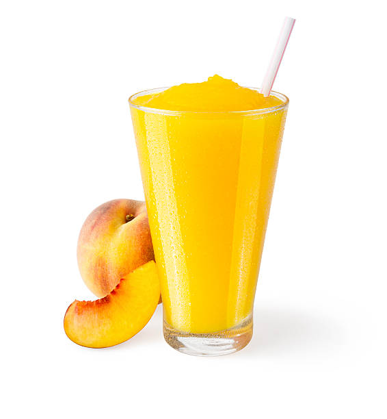 Peach Smoothie with Garnish on White Background A peach smoothie in a generic glass on a white background with a garnish of peaches on the side. orange smoothie stock pictures, royalty-free photos & images