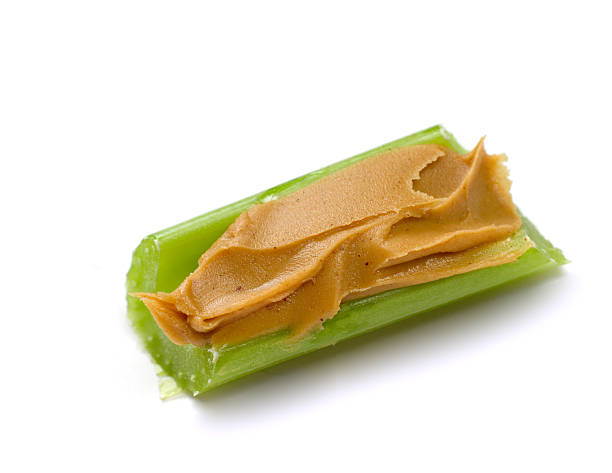 Peanut Butter on Celery (Macro, XXL) Rich, textured peanut butter spread atop a stick of celery. GIANT 16+ MP image. celery stock pictures, royalty-free photos & images