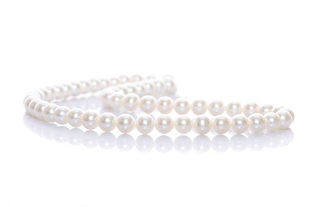 Pearl necklace over white background Pearl necklace with reflection on white background necklace stock pictures, royalty-free photos & images