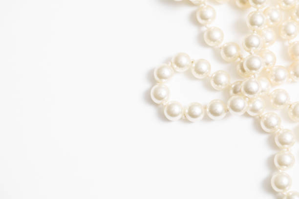 Pearls White Background On A Necklace Pearls on a pearl necklace against a white background pearl jewelry stock pictures, royalty-free photos & images