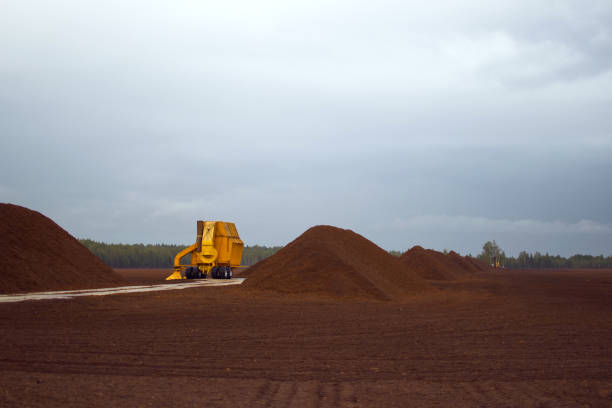 Peat or turf production: machine harvesting peat on the field stock photo