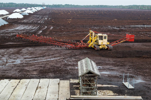 Peat or turf production: machine harvesting peat on the field stock photo