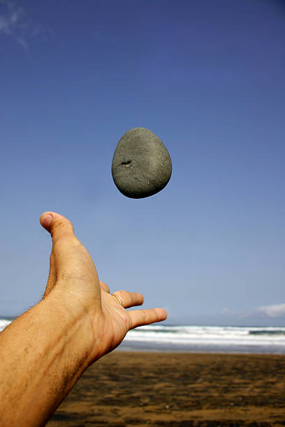 Pebble and Hand on the Beach stock photo