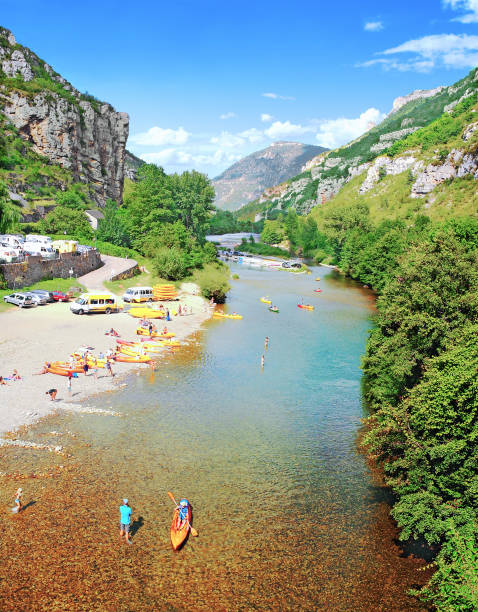 Pebble beach on the Tarn in summer. La Malène beach in the Tarn. July 31, 2014. Each year, over a million visitors come to admire the Gorges du Tarn. In addition to many water activities, the river offers wild landscapes, such as pebble beaches and a majestic canyon. gorges du tarn stock pictures, royalty-free photos & images