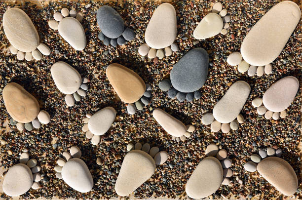 Pebble stones arranged like footprints on the beach stock photo