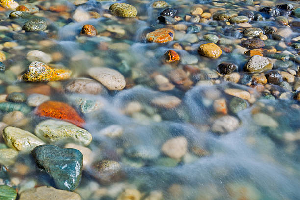 Photo of Pebble stones in the river water close up view,