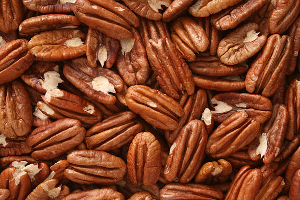 Pecan nuts background Top view of halved pecan nuts pecan stock pictures, royalty-free photos & images