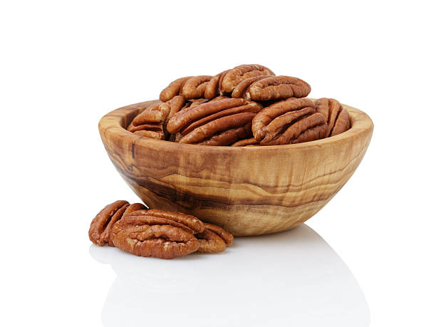 pecan nuts in wood bowl - pecannoot stockfoto's en -beelden