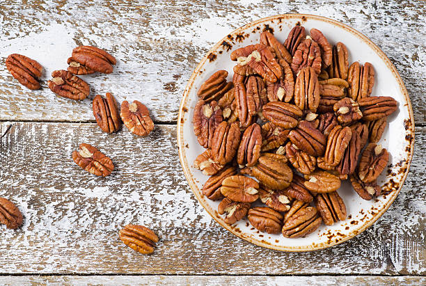 pecan nuts on a wooden table. - pecannoot stockfoto's en -beelden