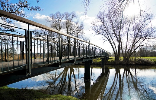 Landscape on the Ems near Telgte, North Rhine Westphalia. Pedestrian bridge over a river with a wintry landscape.