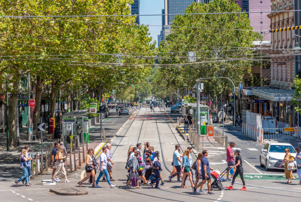 Pedestrians are crossing the road at the intersection of Bourke and Spring Streets on a warm sunny day stock photo