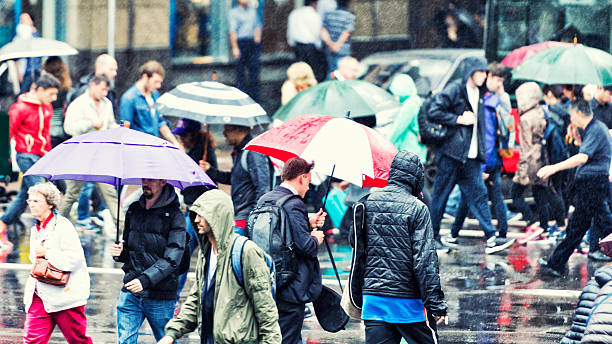 Pedestrians crossing during rain stock photo