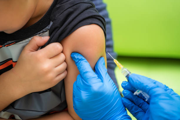 Pediatrician makes vaccination to a small boy. stock photo
