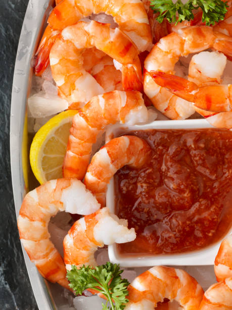 Peel and Eat Shrimp on Ice with Cocktail Sauce Peel and Eat Shrimp on Ice with Cocktail Sauce shrimp cocktail stock pictures, royalty-free photos & images