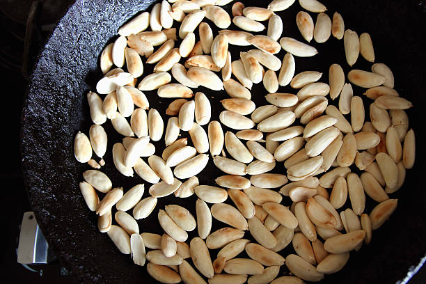 Peeled almonds fried in a pan.. stock photo