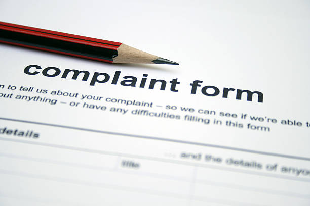Pencil lying on top of a complaint form A red sharpened pencil sits on the heading of a blank complaint form.  The form has black text printed on white paper. complaining stock pictures, royalty-free photos & images