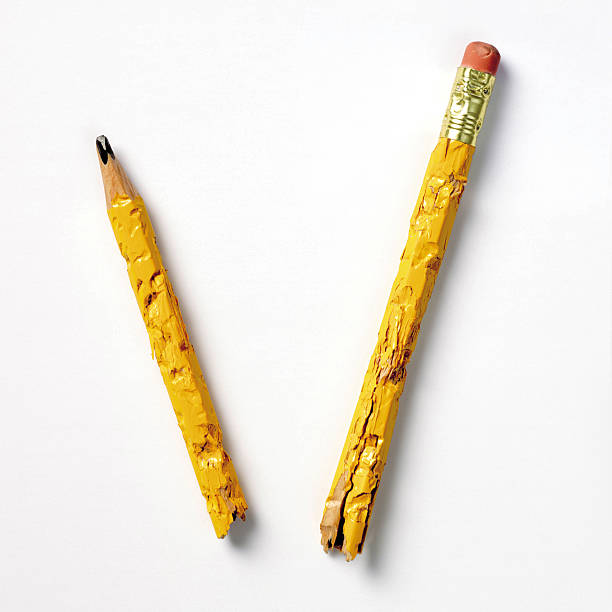 Pencil nibbled and broken in two on white background stock photo