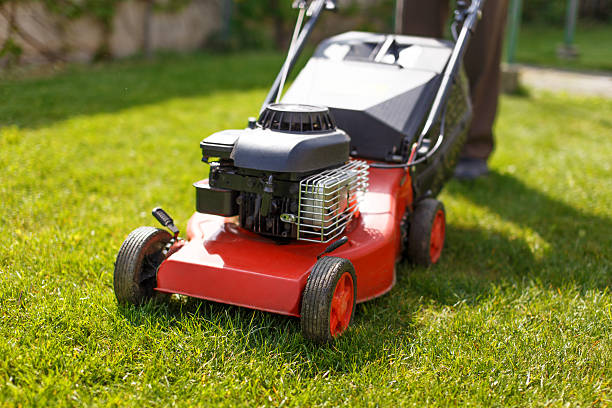 Pensioner mowing lawn with machine stock photo