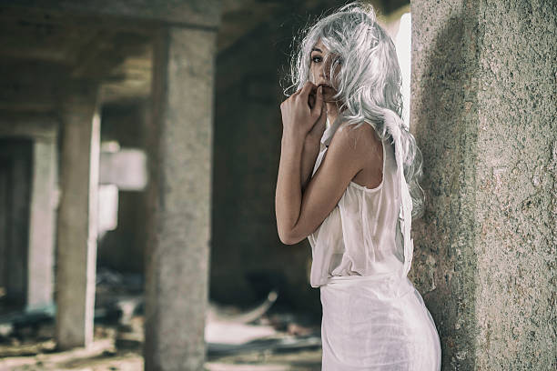 Pensive angel in a ruin looking away. Beautiful female angel in a ruin. white hair young woman stock pictures, royalty-free photos & images