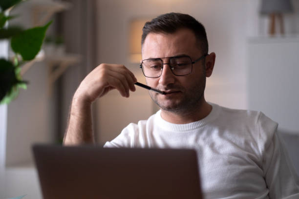 Pensive businessman work on laptop making decision Pensive businessman work on laptop making decision thinking stock pictures, royalty-free photos & images