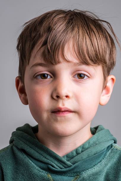 Pensive Caucasian little boy looking at the camera stock photo