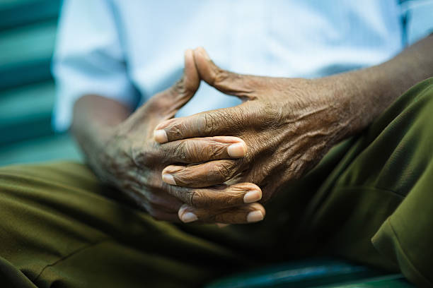 pensive old man sitting on bench in park closeup of hands of elderly african american man sitting on bench sad old black man stock pictures, royalty-free photos & images