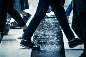 雨の日に横断歩道を渡る人々