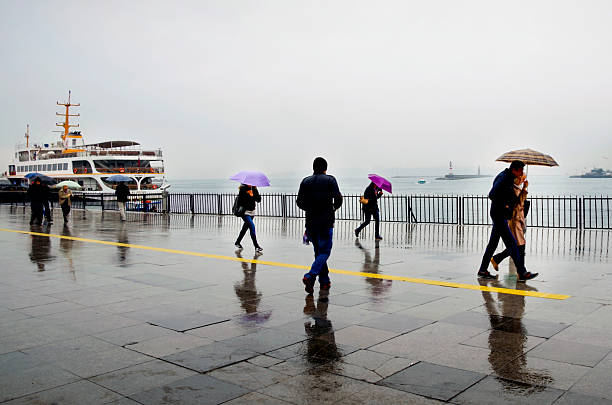 People are trying to reach the ferry pier in Kadikoy Istanbul, Turkey - April 18, 2014: Rain in Istanbul,, People are trying to reach the ferry pier in Kadikoy. m.myfre stock pictures, royalty-free photos & images