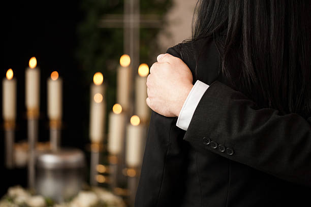 People at funeral consoling each other Religion, death and dolor  - couple at funeral consoling each other in view of the loss funeral parlor stock pictures, royalty-free photos & images
