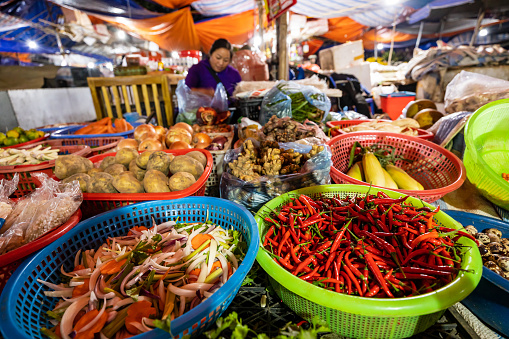 Bac Ha, Lao Cai, Vietnam - November 09, 2019: the Bac Ha Market in north of Vietnam with vegetables and a market woman in the background