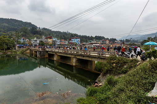 Bac Ha, Lao Cai, Vietnam - November 09, 2019: People on the bridge  going to the market of  Bac Ha in north of Vietnam
