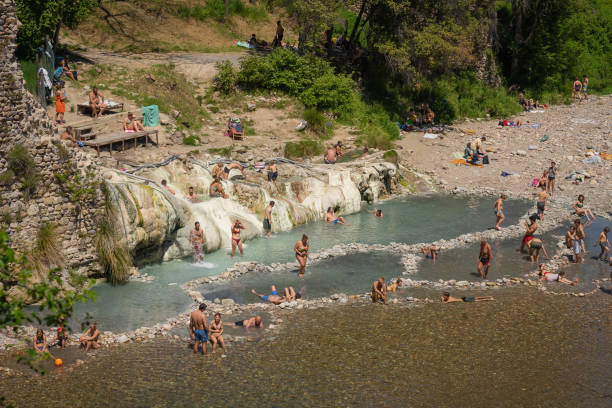 People bathing in pools of thermal spring Bagni di Petriolo in Siena, Tuscany, Italy stock photo