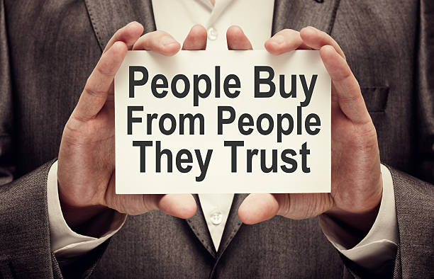 People Buy From People They Trust People Buy From People They Trust. Businessman holding a card with a message text written on it bonding stock pictures, royalty-free photos & images