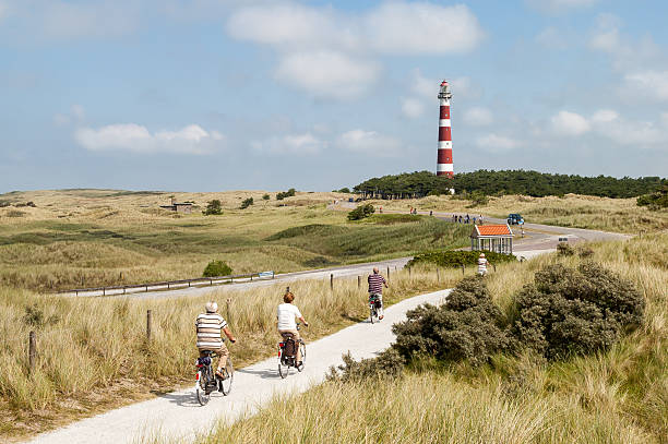 People cycling in dunes of Ameland, Netherlands stock photo
